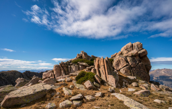 Каменные горы под голубым небом с белыми облаками 