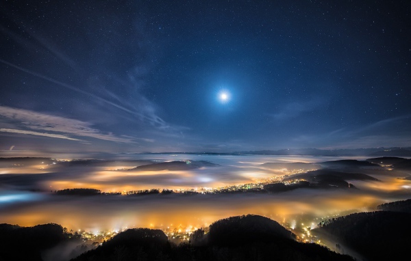 Вид с горы на покрытый туманом ночной город 