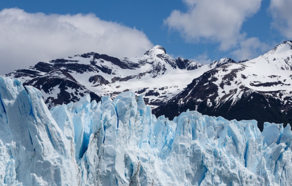 Голубой ледник на фоне заснеженных гор 