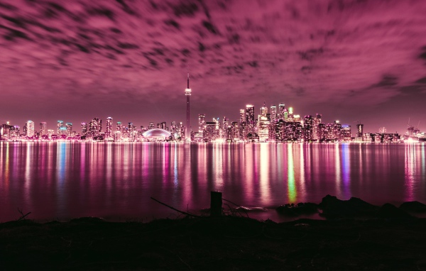 Ночной город под голубым небом отражается в воде 