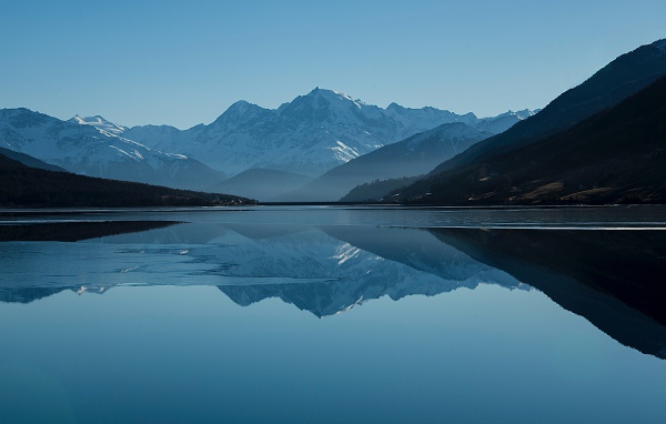 Холодное озеро покрывается льдом у гор