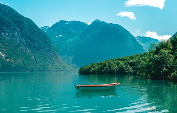 Лодка на голубой воде озера в горах 