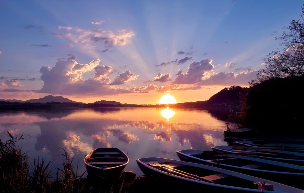 Лодки на берегу озера на закате солнца