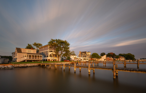 Мост у дома над тихой рекой под красивым небом