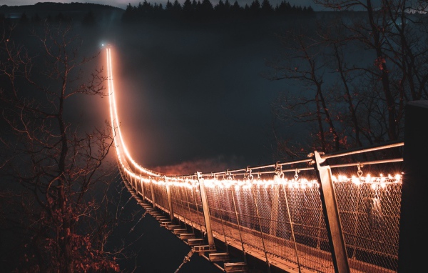 Мост с фонарями через реку в тумане ночью 
