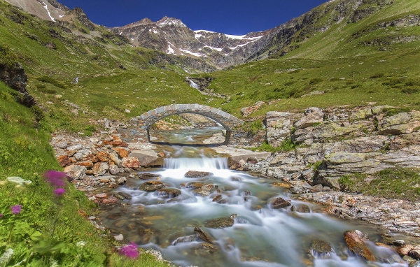 Маленький каменный мост через горную реку 