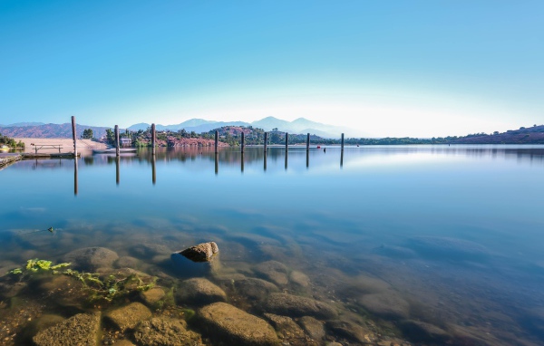 Камни в озере на фоне голубого неба