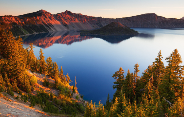 Небо отражается в горном озере в лучах солнца