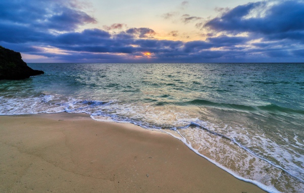Голубая морская вода на песке на закате солнца