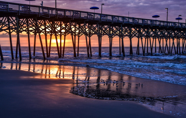 Кафе на мосту у моря на закате 