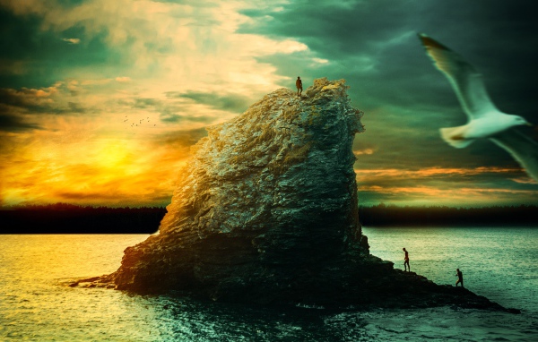 Скала в море на закате солнца