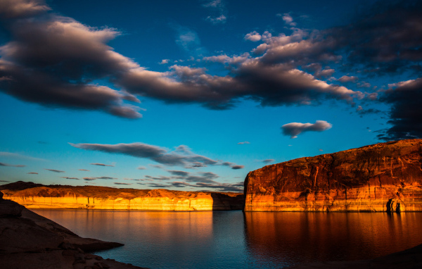 Скалы  в воде под голубым небом с облаками 