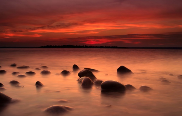 Камни в речной воде на закате солнца 