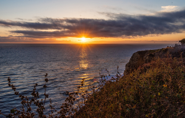Вид на закат солнца в темных облаках в небе над морем 
