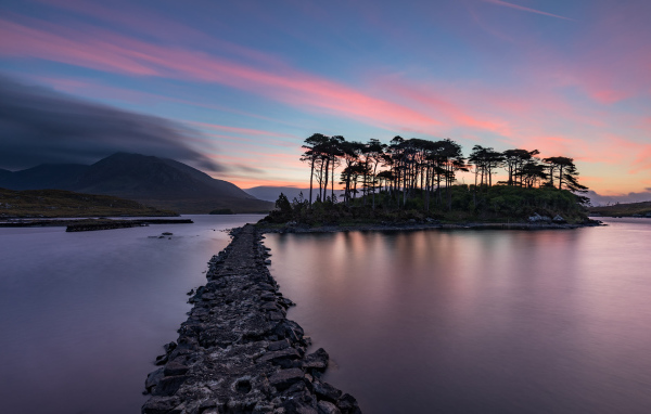 Дорога ведет к острову на фоне голубого заката