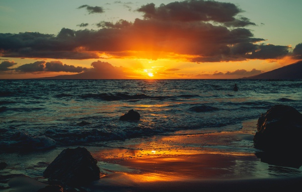 Мокрый песок на берегу океана на закате