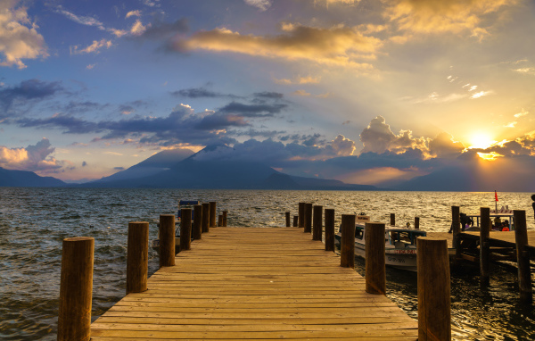 Деревянный мост в море на закате солнца 