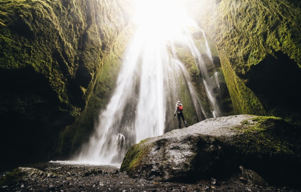 Быстрый водопад стекает между скал 