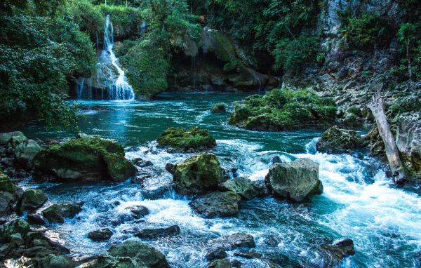 Голубая вода в водопаде стекает по камням 