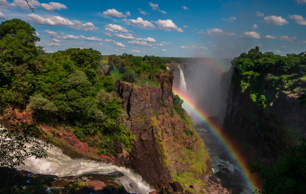 Радуга над водопадом на утесе 