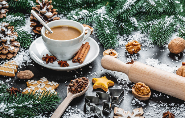 Чашка горячего какао на столе  еловыми ветками и орехами
