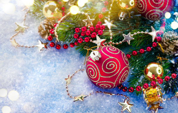 Яркие елочные украшения на снегу с веткой 