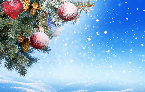 Еловая ветка с игрушками на голубом фоне на Новый год 