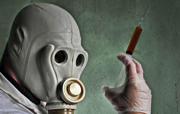 Мужчина в противогазе со шприцем в руках, пандемия коронавирус