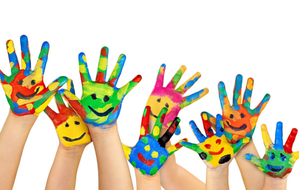 Смайлики нарисованы красками на руках детей на белом фоне