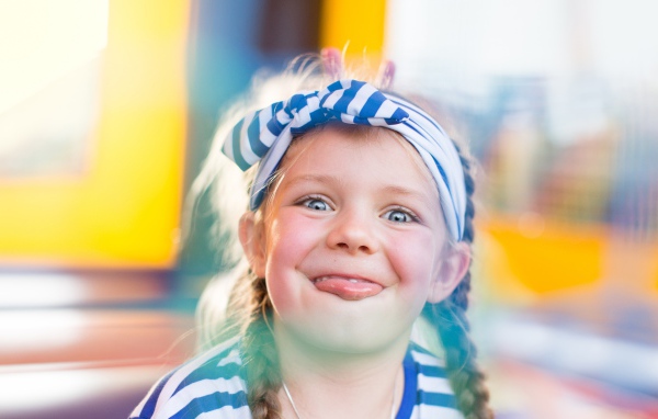 Забавная маленькая девочка с повязкой на голове