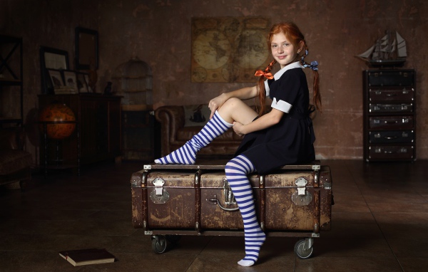 Девочка в школьной форме сидит на чемодане 