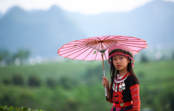 Маленькая девочка азиатка с розовым зонтом