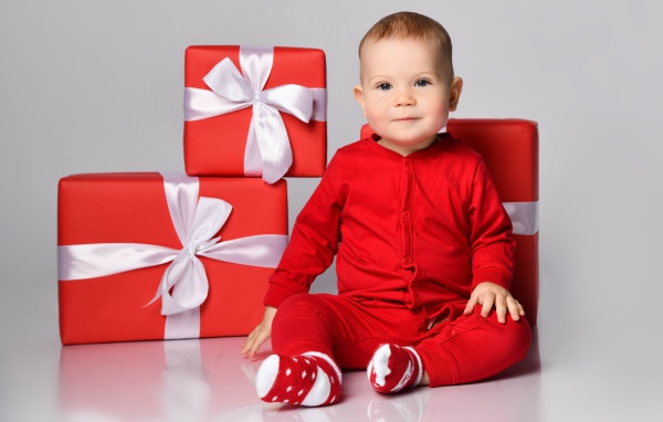 Маленький мальчик в красном костюме с подарками