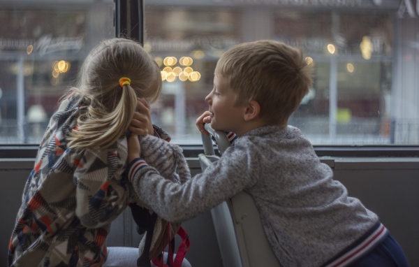 Маленькие девочка и мальчик сидят в автобусе 