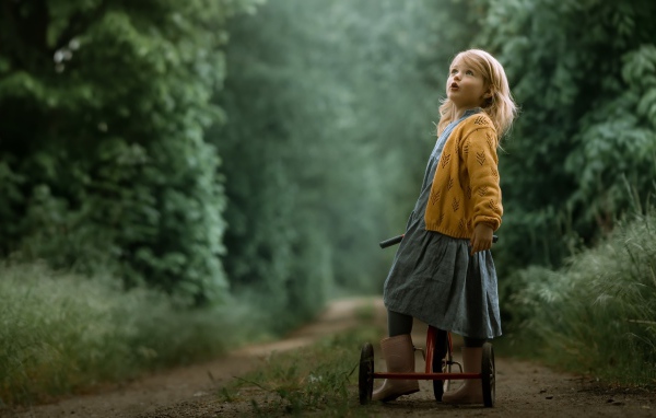 Маленькая девочка на трехколесном велосипеде 