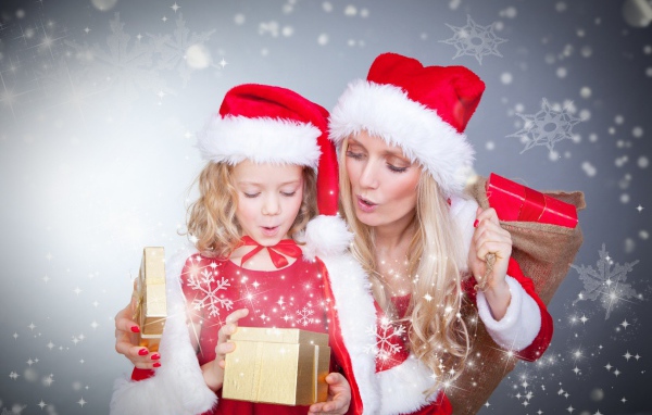 Маленькая девочка с мамой в новогодних костюмах с подарками