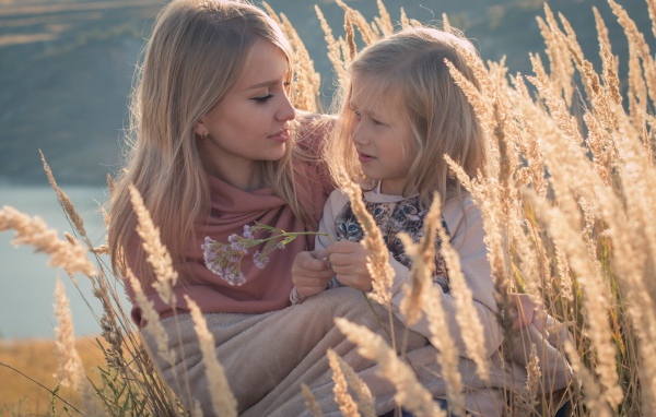 Маленькая девочка с мамой на поле с колосками 