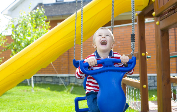 Улыбающийся ребенок на качели 