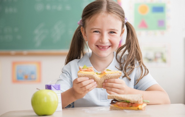 Улыбающаяся девушка школьница в столовой 