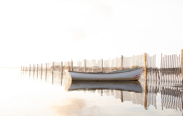 Лодка в воде у ограждения 