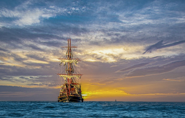 Большой пиратский корабль в море на закате 