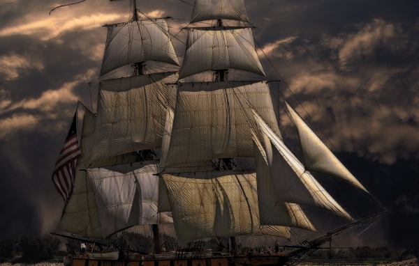 More ship with white sails against the sky at dusk