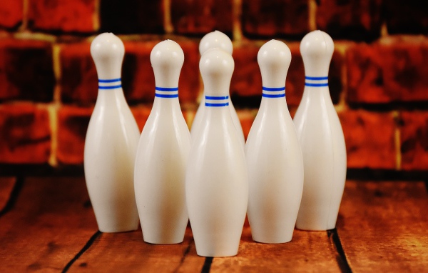 Белые кегли стоят у стены 