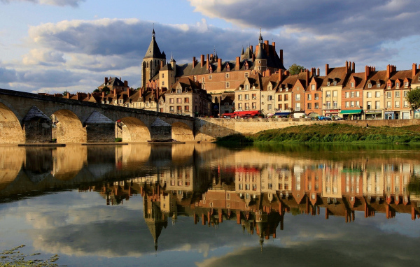 Большой дом отражается в реке у моста, Франция