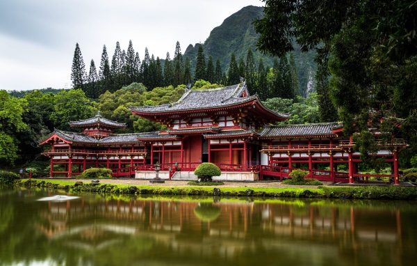 Red temple building near the water on a background of a mountain, Japan