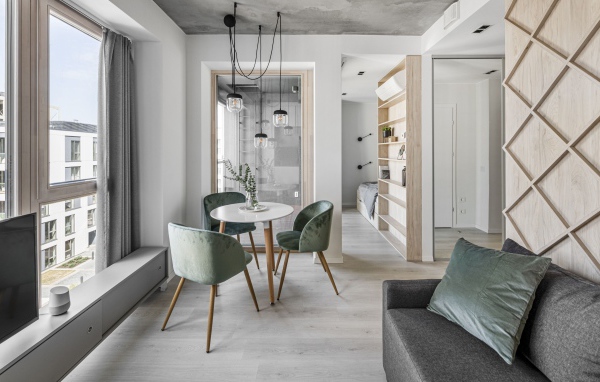 Стол  с креслами стоит у большого окна в квартире 