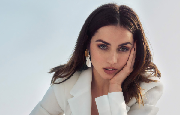 Актриса Ана де Армас в белом пиджаке на сером фоне