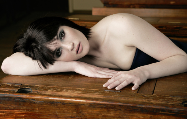 Актриса Джемма Артертон лежит на деревянном столе