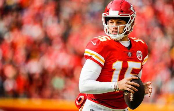 Игрок в американский футбол Патрик Махоумс на поле с мячом