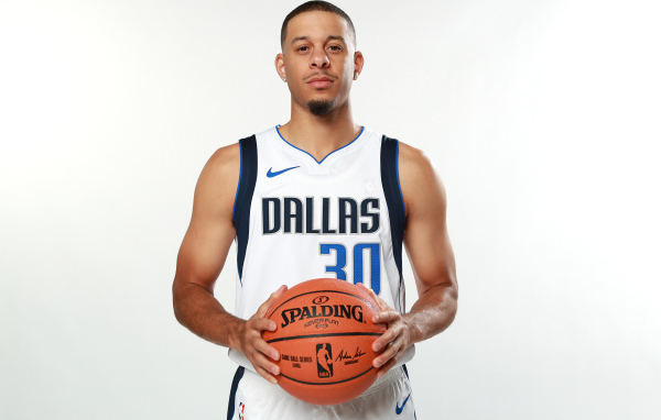 Баскетболист Сет Карри с мячом в руках на белом фоне